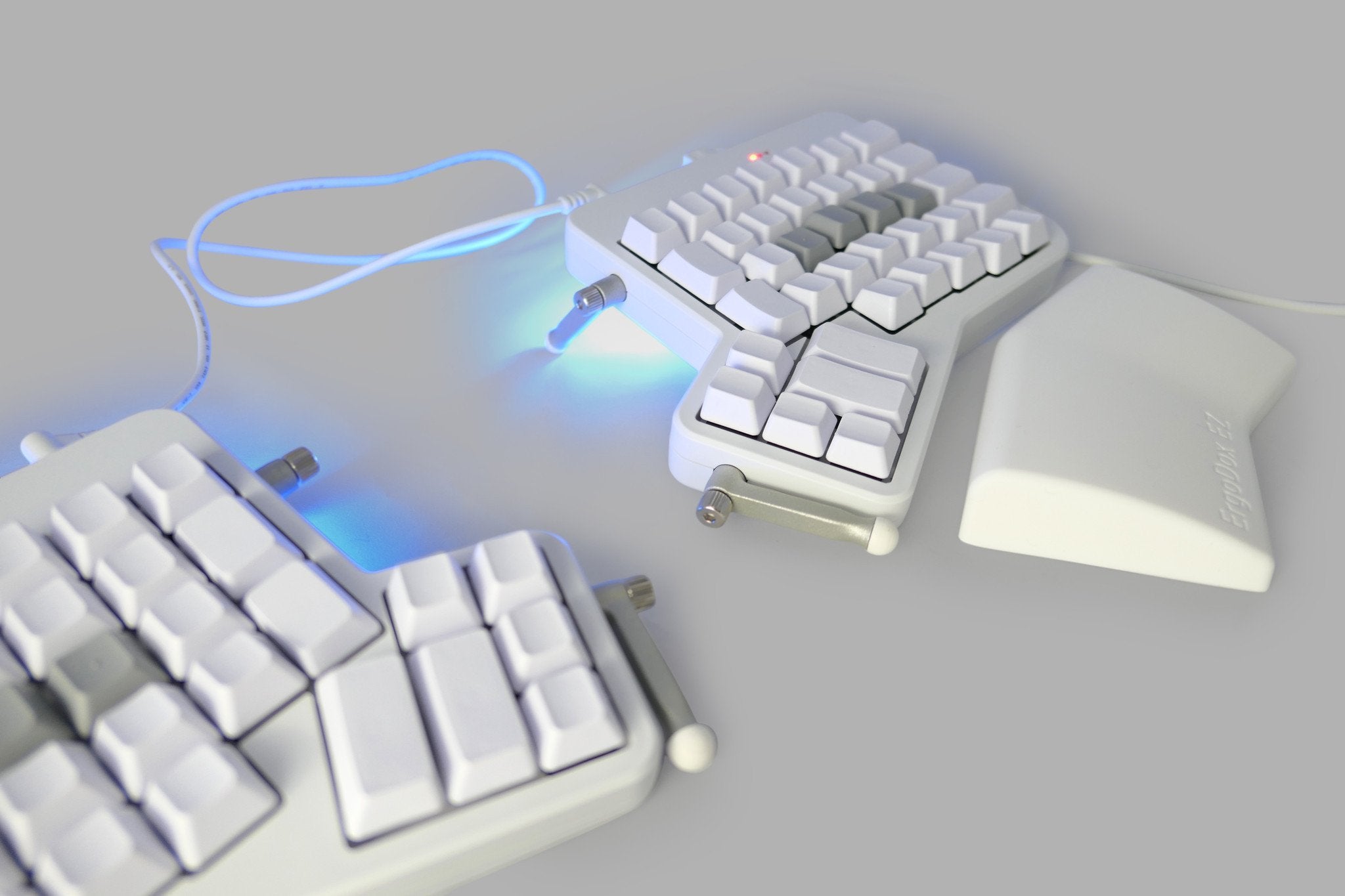 An ErgoDox EZ, a white split keyboard with blank keycaps.