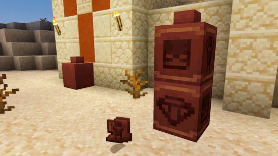 Minecraft update 1.20 - Archeology - several brown pots with paianted designs of a skeleton and diamond on their sides, stacked in the desert by a temple