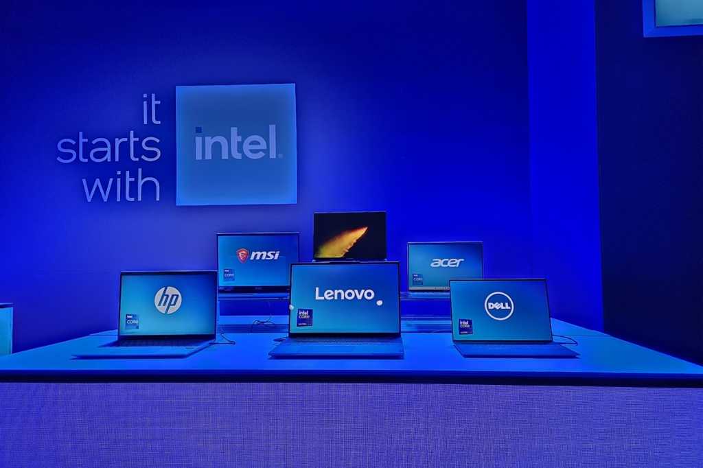 A group of laptops on a table with an "It starts with Intel" sign behind them.